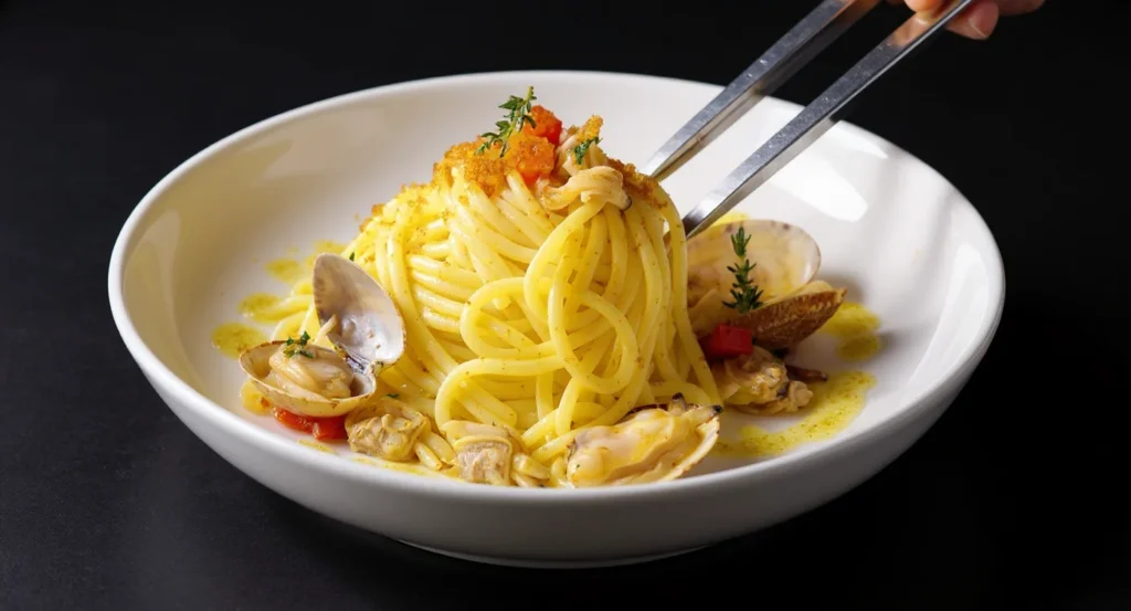 Creamy Garlic Seafood Pasta with spaghetti, fresh clams, and aromatic herbs in a white bowl.